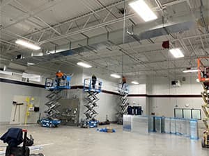 Interior view of a warehouse with industrial lighting and concrete flooring completed by Jeff Smith Construction in Woodland, CA.