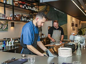 Bartender serving drinks at the bar of Omakase Restaurant built by Jeff Smith Construction in Tahoe, CA.