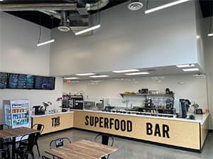 Interior of a Superfood bar restaurant with modern wood finishes and lighting completed by Jeff Smith Construction in Fair Oaks, CA.