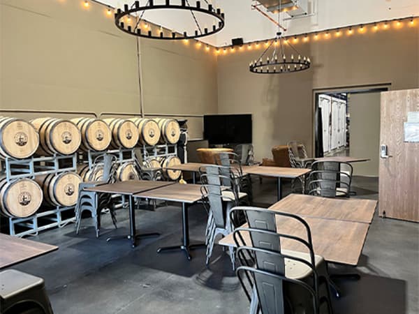 Restaurant-style tasting room with wine barrels and seating designed by Jeff Smith Construction in Rescue, CA.