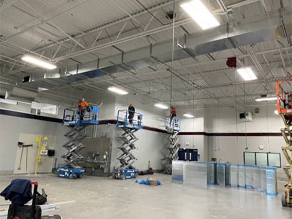 Interior view of a warehouse with industrial lighting and concrete flooring completed by Jeff Smith Construction in Woodland, CA.