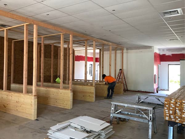 Split image showing Jeff Smith Construction crew flattening freshly poured concrete and building wooden plank structures for an axe-throwing bar project in Rocklin, CA.