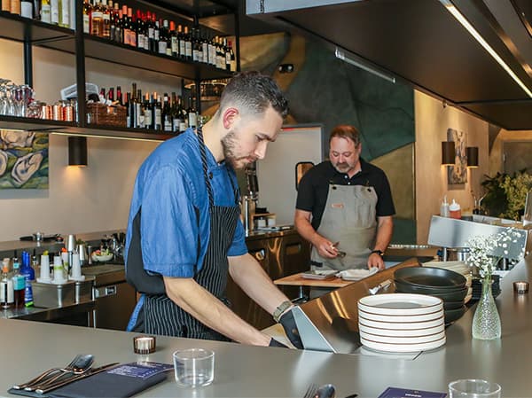 Bartender serving drinks at the bar of Omakase Restaurant built by Jeff Smith Construction in Tahoe, CA.