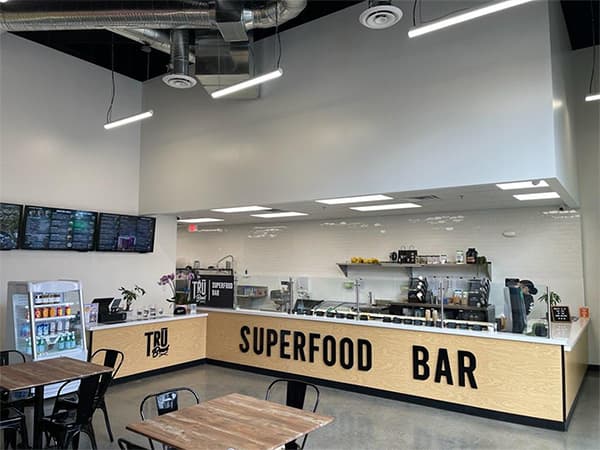 Interior of a Superfood bar restaurant with modern wood finishes and lighting completed by Jeff Smith Construction in Fair Oaks, CA.