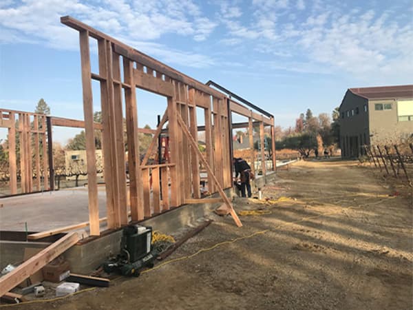 Home framing by Jeff Smith Construction in Roseville. Jeff Smith Construction employee setting up the wooden frame of a new residential home build in Roseville, CA.